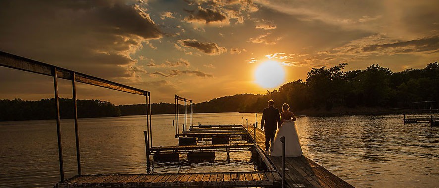 Bride and groom walking down dock on Lake of Egypt