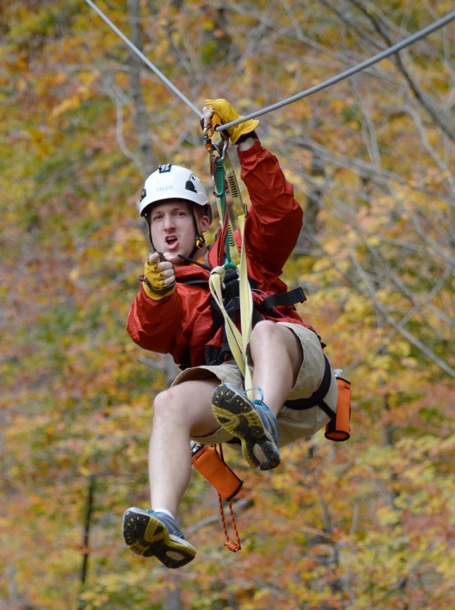 Man pointing at camera on zip line